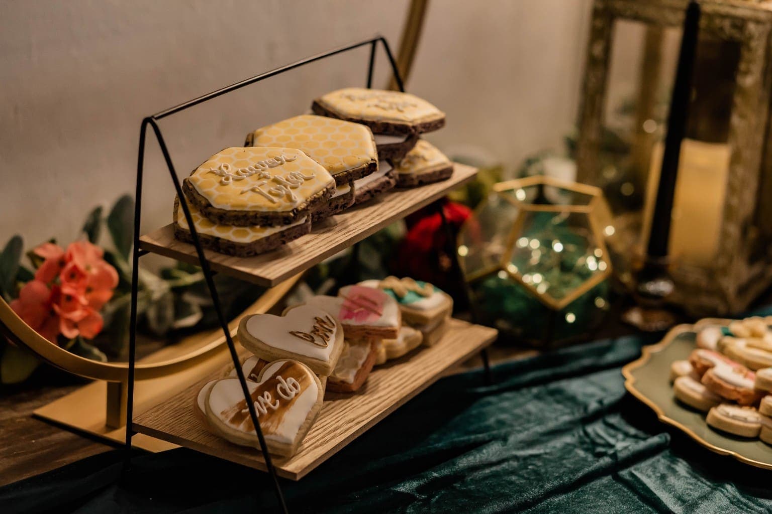 Custom wedding cookies with honeycomb and heart designs on a two tier wooden stand